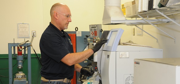 Technician operating a machine for cement testing.